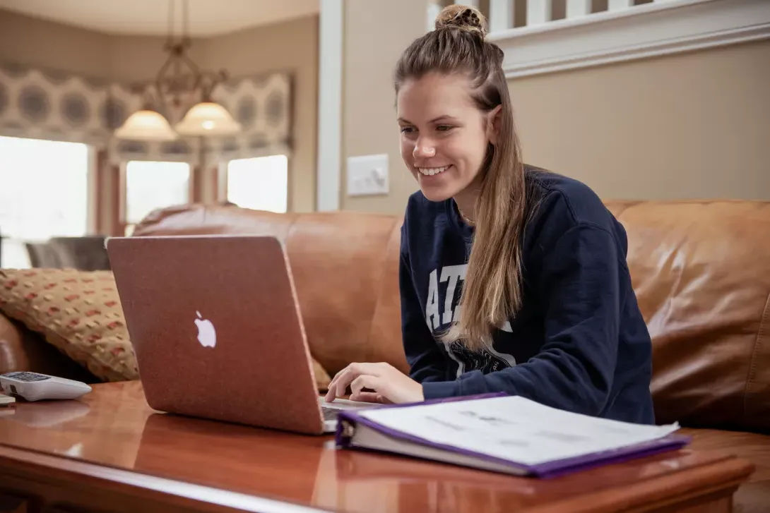 student working on laptop, online class